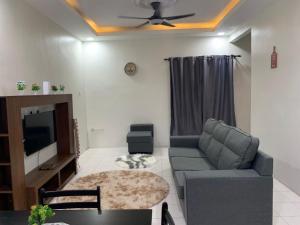 sala de estar con sofá y TV en Homestay Maryam en Lumut