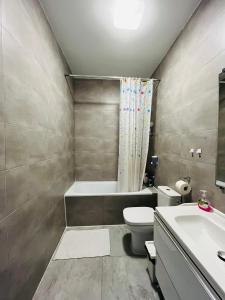a bathroom with a toilet and a tub and a sink at airport comfy guest home in Warsaw