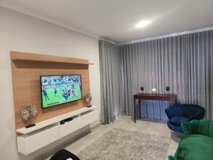 a living room with a flat screen tv on a wall at Sarona city Habitat Alpha apartments C202 Gaborone in Gaborone