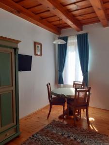 comedor con mesa, sillas y ventana en Fény-Szer Vendégház Őrség, en Szentgotthárd