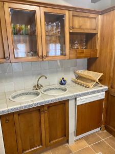 una cocina con 2 lavabos y armarios de madera en Cal Cuaresma en Isona