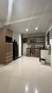 a large kitchen with wooden cabinets and a black refrigerator at Mi casa es tu casa ! in Santa Cruz de la Sierra