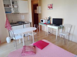 a room with a kitchen and a table with a computer at Hôtel Moderne Veynes -Appart Hôtel- in Veynes