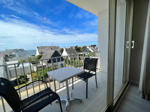 a balcony with a table and chairs and a view of the ocean at Hôtel Ker-Noyal Quiberon Plage in Quiberon
