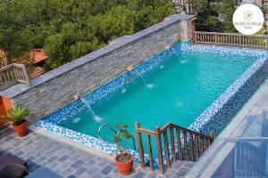 una gran piscina con una pared de ladrillo en Basera Boutique Hotel, en Katmandú