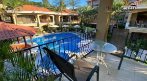 uma varanda com uma mesa e uma piscina em Monte Carlo Luxury Condominiums em Jacó