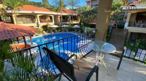 a balcony with a table and a swimming pool at Monte Carlo Luxury Condominiums in Jacó