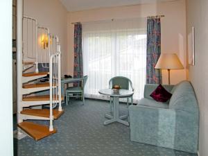 ein Wohnzimmer mit einer Treppe, einem Sofa und einem Tisch in der Unterkunft Hotel Grüner Baum in Genthin