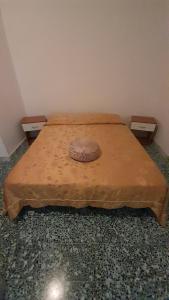 ein Schlafzimmer mit einem Bett mit einer braunen Bettdecke darauf in der Unterkunft Casa Concetta in Marina di Fuscaldo