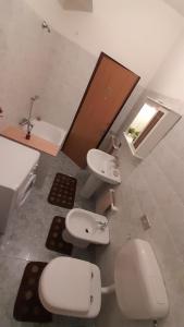 ein Badezimmer mit 2 WCs, einem Waschbecken und einer Badewanne in der Unterkunft Casa Concetta in Marina di Fuscaldo