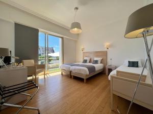 a hotel room with two beds and a balcony at Hôtel Ker-Noyal Quiberon Plage in Quiberon