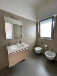 ein Badezimmer mit einem Waschbecken, einem WC und einem Spiegel in der Unterkunft MINIAPART VICO V in Bari