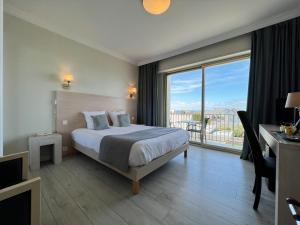 a hotel room with a bed and a large window at Hôtel Ker-Noyal Quiberon Plage in Quiberon