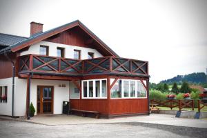 a large house with a wooden building with a porch at Apartmán Restaurace 16 