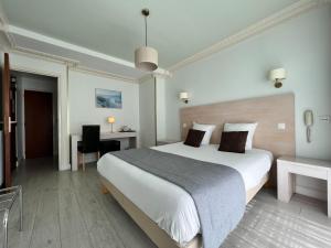 a hotel room with a large bed and a desk at Hôtel Ker-Noyal Quiberon Plage in Quiberon