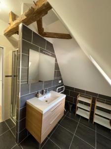 La salle de bains est pourvue d'un lavabo et de carrelage noir. dans l'établissement La loge d’Evelyne, à Villecomtal