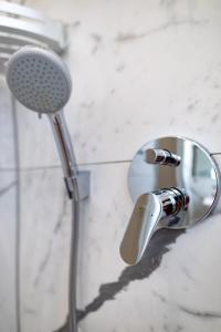 a shower head and a mirror in a bathroom at Cozy studio, private garden, 8 min to city center in Vienna