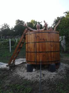 twee mensen in een houten vat bij Pensiunea turistica "Casa rustica" in Chişcăreni