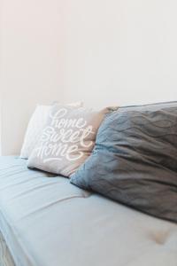 a bed with a pillow that says home sweet home at Cozy studio, private garden, 8 min to city center in Vienna