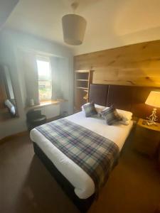 - une chambre avec un grand lit et une couverture tressée dans l'établissement Ravelston House, à Musselburgh