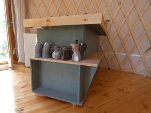 a shelf in a room with some jars on it at modern Mongolian yurt in Grohoţele
