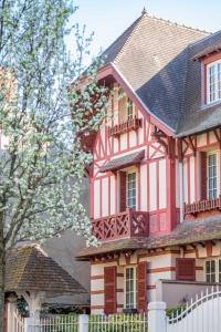 Cette grande maison rouge et blanche dispose d'un balcon. dans l'établissement Maison de caractère en centre ville, à Vichy