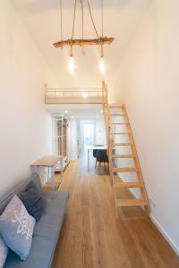 uma sala de estar com uma escada, um sofá e uma mesa em Cozy studio, private garden, 8 min to city center em Viena