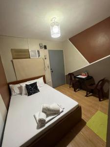 1 dormitorio con 1 cama y 1 mesa con sillas en DJCI Apartelle Small Rooms, en Cabanatúan