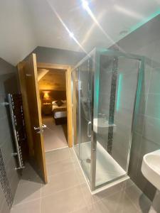 W łazience znajduje się szklana kabina prysznicowa i umywalka. w obiekcie Ravelston House w mieście Musselburgh