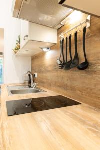 uma cozinha com um lavatório e utensílios numa parede em Cozy studio, private garden, 8 min to city center em Viena
