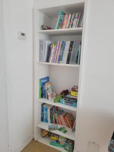 uma estante cheia de livros em Ker Armand, appartement Thabor proche hyper centre em Rennes