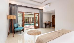 a bedroom with a bed and a dining room at KU Villas in Kuta Lombok