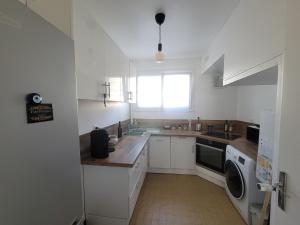 a white kitchen with a sink and a dishwasher at Ker Armand, appartement Thabor proche hyper centre in Rennes