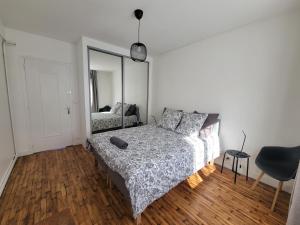- une chambre avec un lit et un miroir dans l'établissement Ker Armand, appartement Thabor proche hyper centre, à Rennes