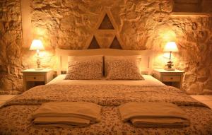 a bedroom with a large bed with two lamps at Olive Coast Suites in Palekastron