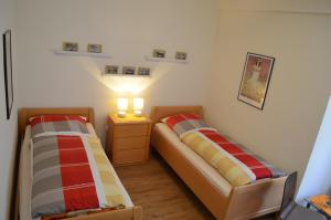 バート・ゾーデン・アレンドルフにあるFerienwohung Villa Cäcilieのベッドルーム1室(ベッド2台、照明付きのナイトスタンド付)