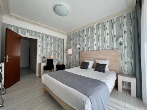 a hotel room with a large bed and a desk at Hôtel Ker-Noyal Quiberon Plage in Quiberon