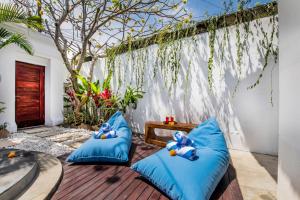 a patio with blue pillows on a wooden deck at Villa Joyosa in Seminyak