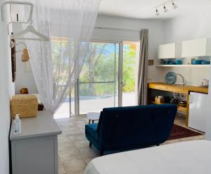 uma sala de estar com um sofá azul e uma janela em La Rústica en Viñuela, piscina privada em Viñuela