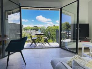 uma sala de estar com vista para uma varanda em BELLA CRUZ 66 m2 prestations premium, wifi, balcon, parking avec borne de recharge électrique, plage Prieuré, Commerces em Dinard