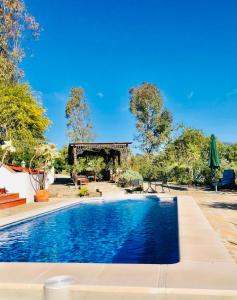 uma piscina num quintal com um gazebo em La Rústica en Viñuela, piscina privada em Viñuela