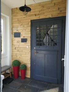 a blue door in front of a wooden wall at Le logis du mineur Chez Agnès et Joël in Staffelfelden