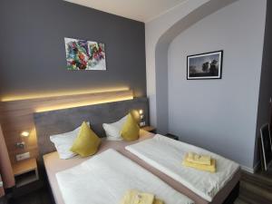 ein Schlafzimmer mit einem großen Bett mit gelben Kissen in der Unterkunft Gasthof Alter Felsenkeller in Naumburg