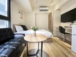 - un salon avec un canapé et une table dans l'établissement 旅行家 Affetto Hostel, à Taichung