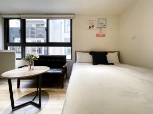 una camera con letto, tavolo e divano di 旅行家 Affetto Hostel a Taichung