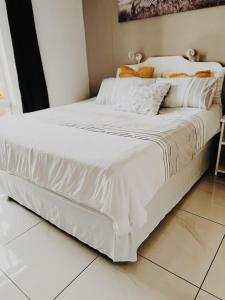 un letto con lenzuola bianche in una camera da letto di Seagull Beach resort flat number 313 a Margate
