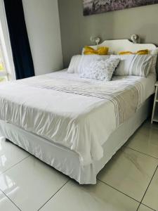 Seagull Beach resort flat number 313 في مارغيت: سرير عليه أغطية ووسائد بيضاء