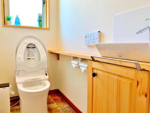 ein Badezimmer mit einem weißen WC und einem Waschbecken in der Unterkunft Villa Yui in Ishigaki-jima