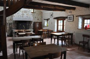 ein Restaurant mit Tischen und Stühlen und einem Kamin in der Unterkunft Ti Aval - Gîte de charme à la campagne - côte de granit rose in Bégard