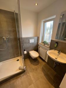 a bathroom with a shower and a toilet and a sink at Hotel-Pension Haus Andrea in Niederkrüchten